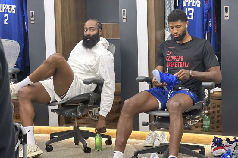 James Harden (izquierda) se sienta junto a Paul George, alero de los Clippers de Los Ángeles, antes del partido del martes 31 de octubre de 2023, ante el Magic de Orlando (AP Foto/Joe Reedy)