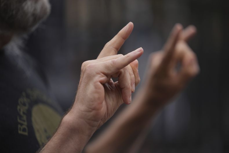 Un fan posa para una fotografía para conmemorar la muerte de Ozzy Osbourne en el puente Black Sabbath en Birmingham, el miércoles 23 de julio de 2025. (Foto AP/Kin Cheung)