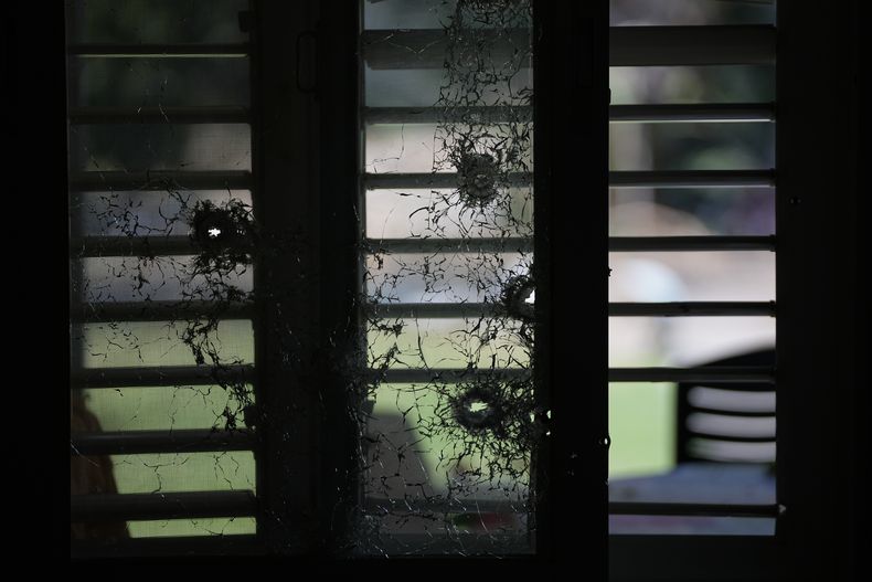 Ventanas perforadas por disparos desde el interior de una residencia, el martes 10 de octubre de 2023, en el kibbutz Kfar Aza. Combatientes de Hamas incursionaron el sábado en Kfar Aza, donde mataron y secuestraron a varios israelíes. (AP Foto/Ohad Zwigenberg)