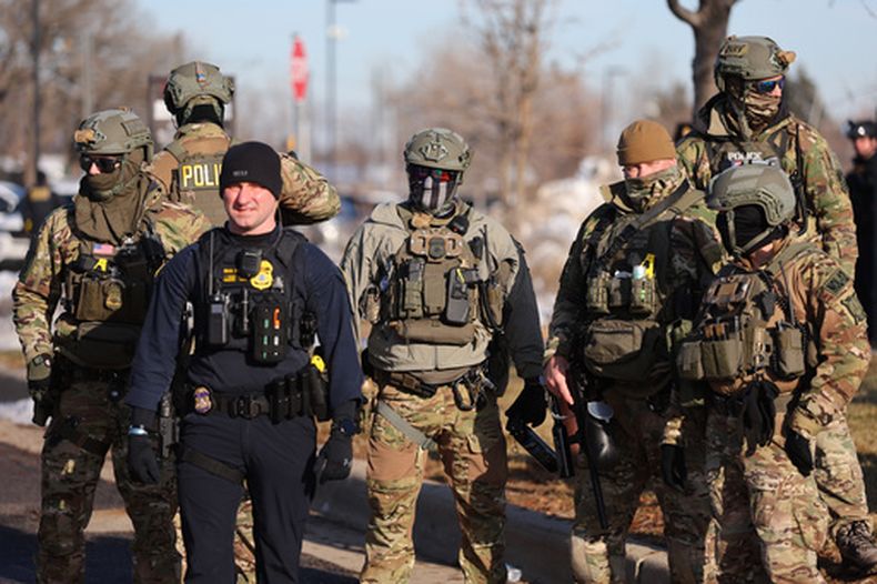 Agentes federales permanecen frente al edificio federal Bishop Henry Whipple al tiempo que los manifestantes se reúnen, en Minneapolis, el viernes 9 de enero de 2026. (Foto AP/Adam Bettcher)