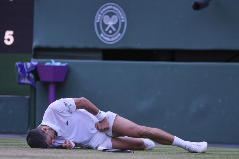 Novak Djokovic de Serbia reacciona después de resbalar y caer al intentar devolver un golpe a Flavio Cobolli de Italia durante un partido de cuartos de final individual masculino en el Campeonato de Tenis de Wimbledon en Londres, el miércoles 9 de julio de 2025. (AP Photo/Kin Cheung)