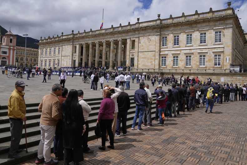 La gente hace fila afuera del Congreso para rendir homenaje al candidato presidencial y senador opositor Miguel Uribe Turbay, quien murió a causa de las heridas sufridas cuando recibió un disparo en un mitin político, en Bogotá, Colombia, el martes 12 de agosto de 2025.(AP Foto/Fernando Vergara)