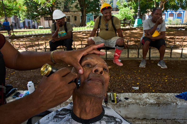 Los trabajadores hacen cola para recibir cortes de pelo gratuitos de los peluqueros del proyecto social Arte Corte en un parque de La Habana, el jueves 28 de mayo de 2026. (Foto AP/Ramón Espinosa)
