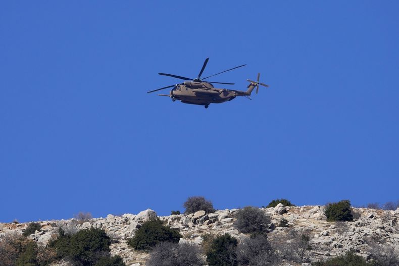 Un helicóptero Black Hawk militar israelí sobrevuela el monte Hermón cerca de la Línea Alfa que separa los Altos del Golán, en Siria, el martes 17 de diciembre de 2024. (AP Foto/Matías Delacroix)