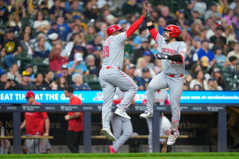 El venezolano Eugenio Suárez le da los cinco al coach de tercera base de los Rojos de Cincinnati Willie Harris tras su jonrón de tres carreras en la sexta entrada ante los Cerveceros de Milwaukee el domingo 13 de septiembre del 2026. (AP Foto/Kayla Wolf)