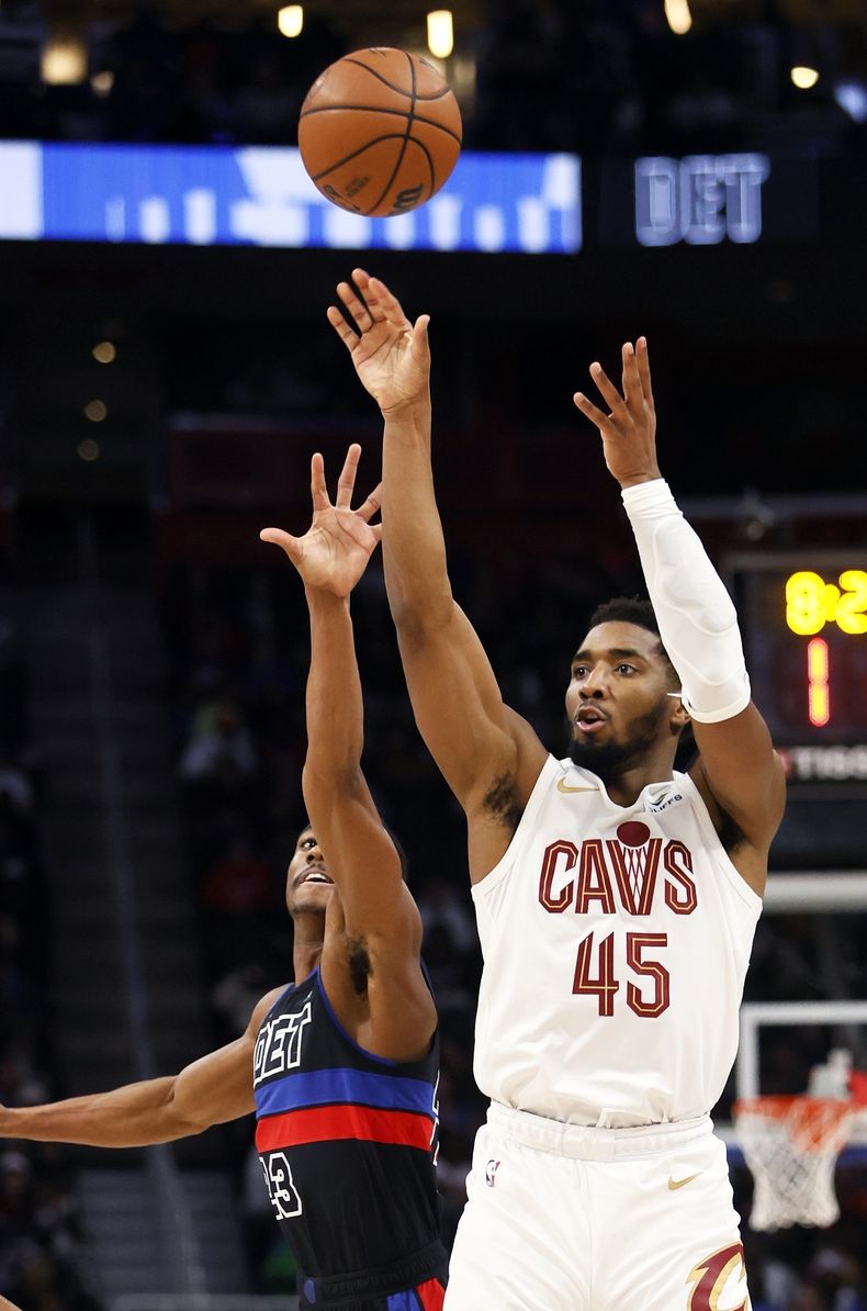 Donovan Mitchell (45) de los Cavaliers de Cleveland dispara ante Jaden Ivey de los Pistons de Detroit, el sábado 2 de diciembre de 2023, en Detroit. (AP Foto/Duane Burleson)