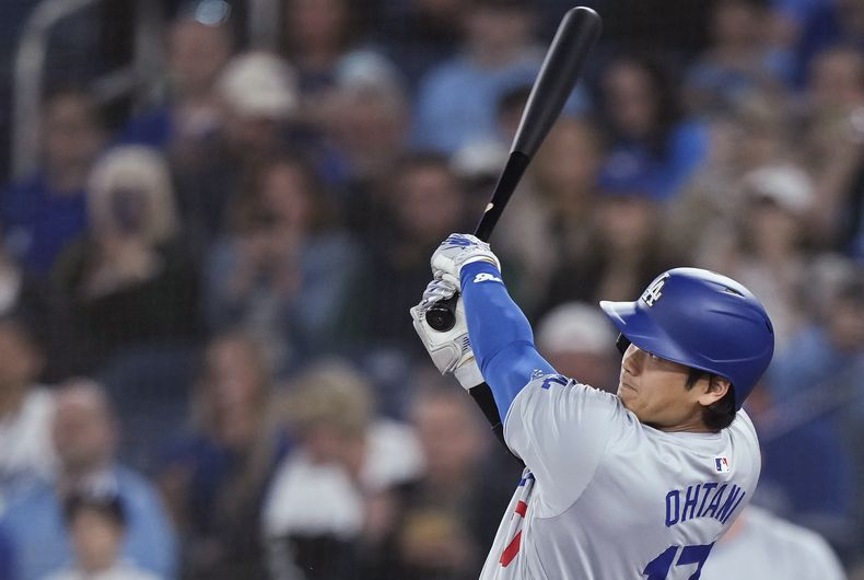 El bateador designado de los Dodgers de Los Ángeles Shohei Ohtani observa su jonrón solitario en la primera entrada del juego ante los Azulejos de Toronto el viernes 26 de abril del 2024. (Nathan Denette/The Canadian Press via AP)