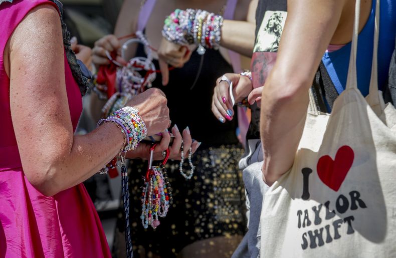 Swifties intercambian brazaletes de la amistad en el centro de la ciudad de Viena el jueves 8 de agosto de 2024. Los organizadores de tres conciertos de Taylor Swift en el estadio de Viena esta semana los cancelaron el miércoles después de que los funcionarios anunciaran arrestos por un aparente complot para lanzar un ataque contra un evento en el área de Viena como los conciertos. (Foto AP/Heinz-Peter Bader)