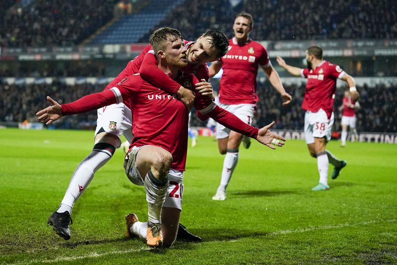 ARCHIVO - Andy Cannon de Wrexham celebra con sus compañeros de equipo después de anotar el primer gol durante el partido de fútbol de cuarta ronda de la Copa FA inglesa entre Blackburn Rovers y Wrexham, en el estadio Ewood Park, en Blackburn, Inglaterra, el lunes 29 de enero de 2024. (Foto AP/Dave Thompson, archivo)