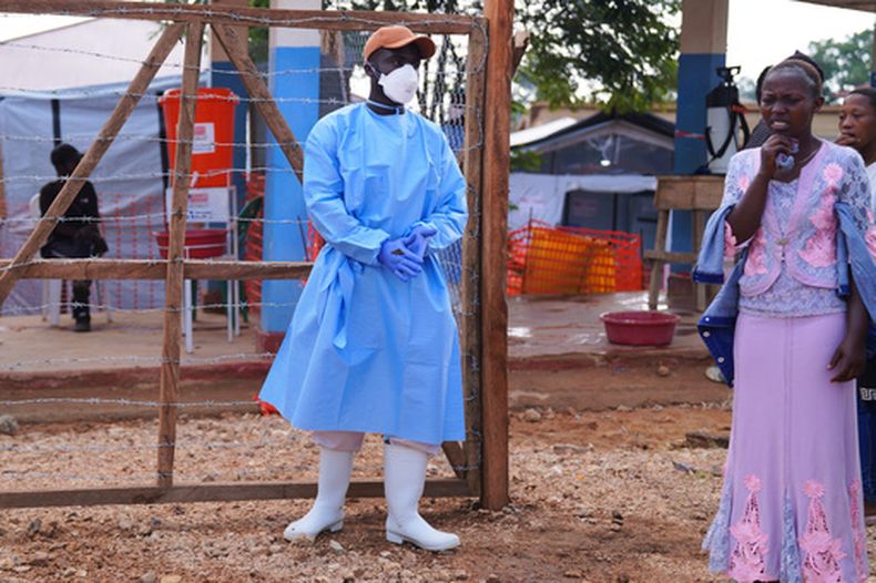 Residentes miran mientras trabajadores sanitarios trasladan un ataúd con los restos mortales de una víctima de ébola, en el Centro de Tratamiento de Ébola del Hospital General de Bunia, en Ituri, República Democrática del Congo, el 22 de julio de 2026. (AP Foto/Dirole Lotsima Dieudonne)