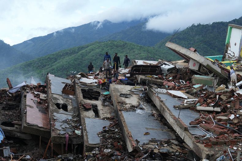 Los residentes buscan entre los escombros de un edificio que se derrumbó durante los terremotos en La Guaira, Venezuela, el martes 30 de junio de 2026. (AP Foto/Ariana Cubillos)