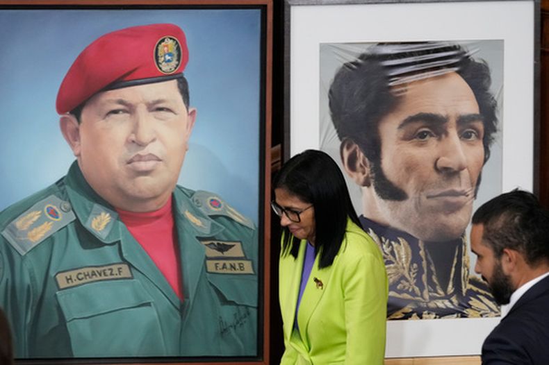 ARCHIVO - La presidenta encargada de Venezuela, Delcy Rodríguez, pasa ante una imagen del expresidente Hugo Chávez, ala izquierda, y el líder de independencia Simón Bolívar en la Asamblea Nacional de Caracas, Venezuela, el 15 de enero de 2026. (AP Foto/Ariana Cubillos, Archivo)