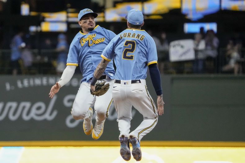 El dominicano Willy Adames y Brice Turang, de los Cerveceros de Milwaukee, festejan tras el triunfo sobre los Filis de Filadelfia, el viernes 1 de septiembre de 2023 (AP Foto/Morry Gash)