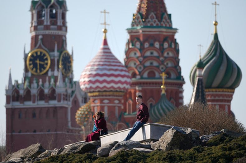 Gente disfrutando del buen tiempo en el parque de Zaryadye en Moscú, el martes 24 de marzo de 2026, con la torre Spasskaya del Kremlin y la catedral de San Basilio al fondo. (AP Foto/Pavel Bednyakov)