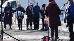 Manifestantes se reúnen mientras agentes vigilan el exterior de un centro de procesamiento del ICE en el suburbio de Broadview, Illinois, en Chicago, el viernes 12 de diciembre de 2025. (AP Foto/Nam Y. Huh)
