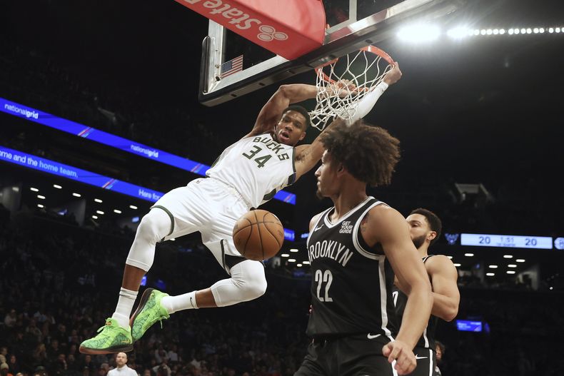 Giannis Antetokounmpo, de los Bucks de Milwaukee, clava el balón ante la presencia de Jalen Wilson y Ben Simmons, de los Nets de Brooklyn, durante la primera mitad del juego de baloncesto de la NBA, el domingo 8 de diciembre de 2024, en Nueva York. (AP Foto/Heather Khalifa)
