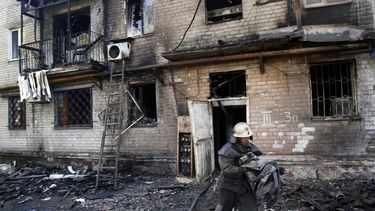 americateve | Un bombero lleva una manguera hasta un edificio da&ntilde;ado por cohetes en la localidad de Donetsk, en el este de Ucrania, el 17 de septiembre de 2014. Dos personas murieron y tres resultaron heridas el mi&eacute;rcoles en la ciudad de Donetsk, en el es
