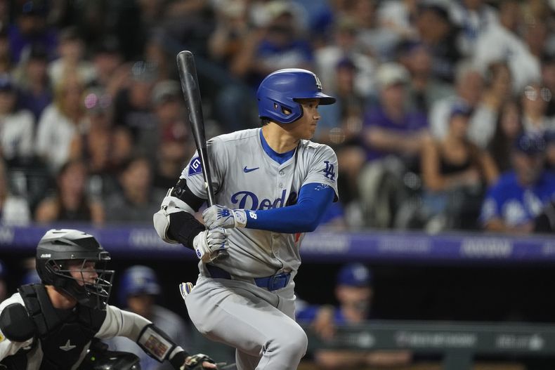 Shohei Ohtani, de los Dodgers de Los Ángeles, sigue con la mirada un batazo que se convirtió en un sencillo frente al relevista de los Rockies de Colorado Jeff Criswell en la sexta entrada del juego de béisbol del sábado 28 de septiembre de 2024, en Denver. (AP Foto/David Zalubowski)