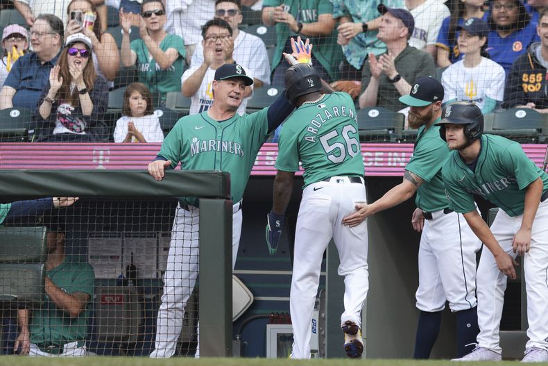 Randy Arozarena de los Marineros de Seattle celebra con el mánager Scott Servais su doble en la primera entrada ante los Mets de Nueva York el sábado 10 de agosto del 2024. (AP Foto/Jason Redmond)