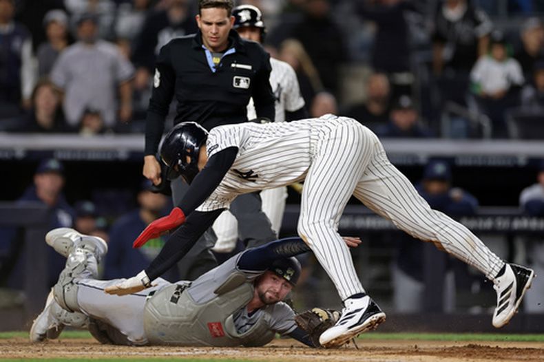 El pelotero George Lombard Jr., de los Yankees de Nueva York, evita ser tocado por el receptor de los Rays de Tampa Bay, Liam Hicks, para anotar una carrera durante la séptima entrada de un partido de béisbol, el 24 de septiembre de 2026, en Nueva York. (Foto AP/Adam Hunger)