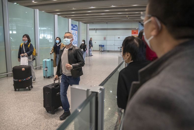 Viajeros con mascarilla caminan por la zona de llegadas internacionales del Aeropuerto Internacional de Beijing, en Beijing, el 15 de abril de 2023. (AP Foto/Mark Schiefelbein)