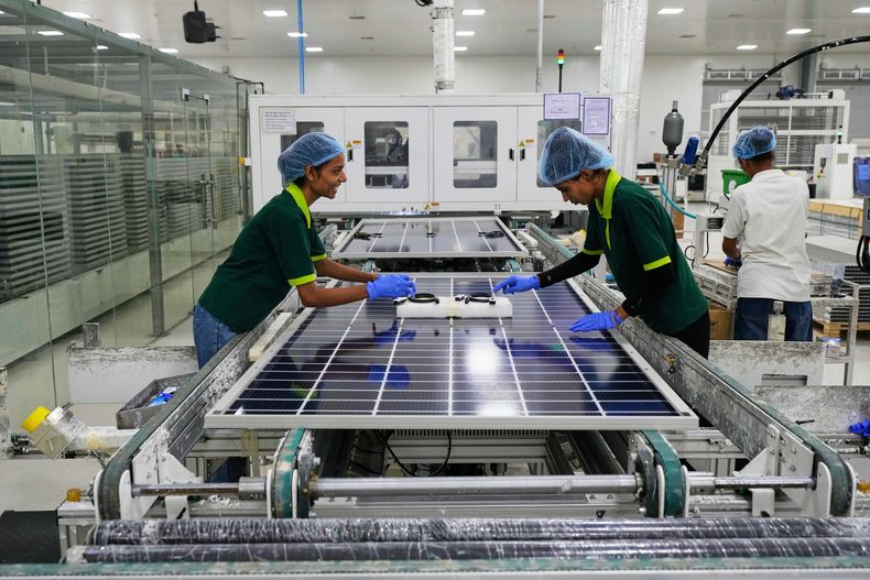 ARCHIVO – Trabajadores instalan interruptores y conectores en paneles solares tras concluir el proceso de enmarcado automático en una planta de fabricación de ReNew en las afueras de Jaipur, India, el 21 de agosto de 2025. (AP Foto/Manish Swarup, Archivo)