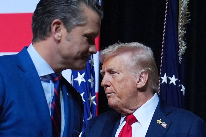 El presidente estadounidense Donald Trump saluda al secretario de Defensa Pete Hegseth entes de hablar en una reunión de comandantes militares de alto rango en la Base del Cuerpo de la Infantería de Marina de Quantico, el martes 30 de septiembre de 2025, en Quantico, Virginia. (AP Foto/Evan Vucci)