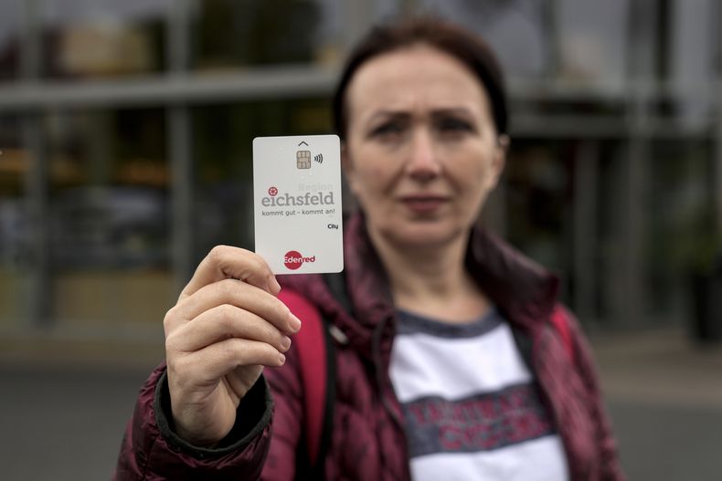 Erdina Laca, una solicitante de asilo de 45 años, muestra una tarjeta de pago especial del gobierno para dar subsidios a migrantes, en Eichsfeld, Alemania, el miércoles 24 de abril de 2024. (Foto AP/Ebrahim Noroozi)