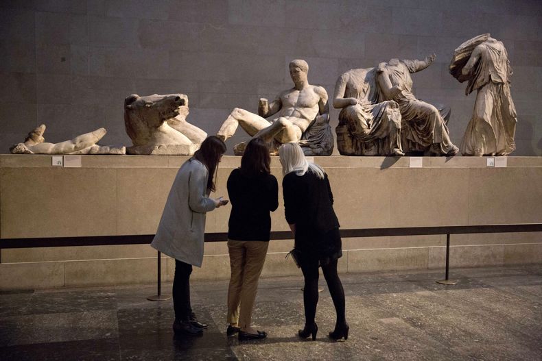 ARCHIVOS - Mujeres contempla una escultura que se cree es del dios griego Diónisos, del pedimento oriental del Partenón, e una exhibición sobre el cuerpo humano en el arte griego antiguo en el Museo Británico, Londres, 8 de enero de 2015. Funcionarios griegos dijeron el martes 28 de noviembre de 2023 que continuarán las conversaciones con el Museo Británico sobre la devolución de los mármoles del Partenón a Grecia a pesar de que el priimer ministro británico Rishi Sunak canceló una reunión con su contraparte griego en la que se preveía hablar sobre las disputadas antigüedades. (AP Foto/Matt Dunham, File)