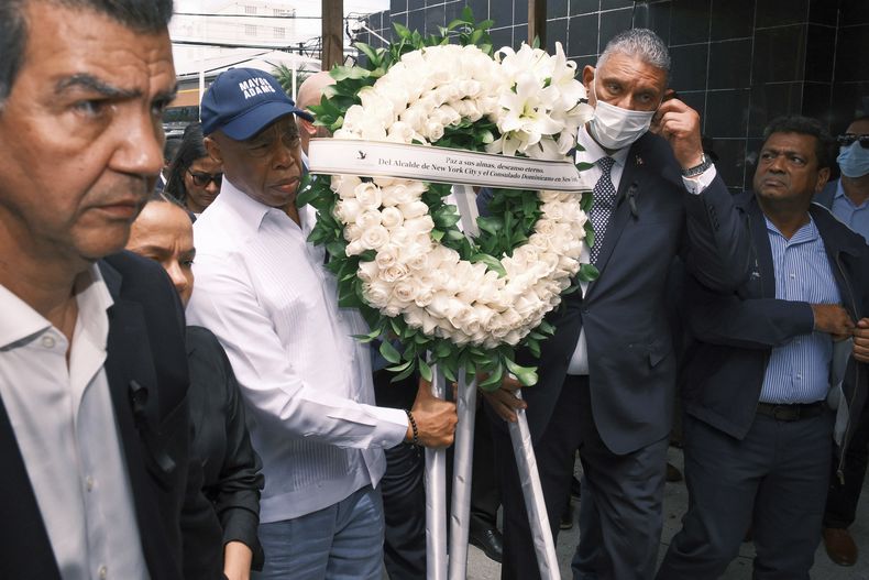 El alcalde de la ciudad de Nueva York, Eric Adams, segundo a la izquierda, lleva una corona de flores en memoria de las más de 200 personas que murieron la semana pasada por el colapso del techo del centro nocturno Jet Set, en Santo Domingo, República Dominicana, el lunes 14 de abril de 2025. (AP Foto/Ricardo Hernández)
