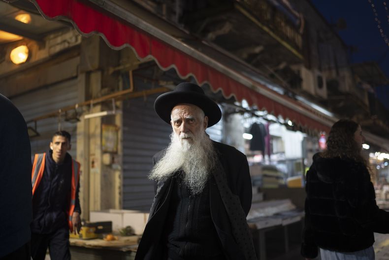 Un judío ultraortodoxo camina en el mercado Mahane Yehuda, el domingo 14 de abril de 2024, en Jerusalén. (AP Foto/Leo Correa)