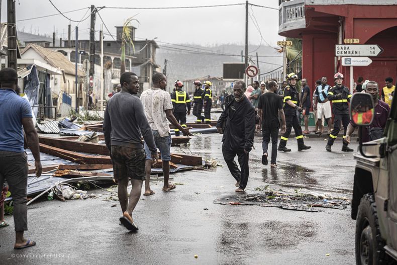 Esta foto proporcionada el lunes 16 de diciembre de 2024 por la Seguridad Civil, muestra a residentes y rescatistas caminando en una calle dañada en el territorio francés de Mayotte, en el océano Índico, después de que la isla fuera azotada por su peor ciclón en casi un siglo. (UIISC7/Securite Civile vía AP)