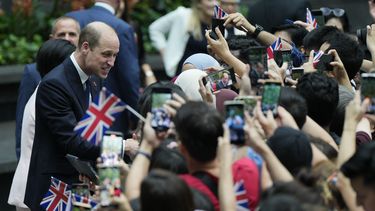 El príncipe Guillermo de Gales, izquierda, es recibido por una multitud a su llegada al Aeropuerto Jewel Changi de Singapur, el domingo 5 de noviembre de 2023. (AP Foto/Vincent Thian)