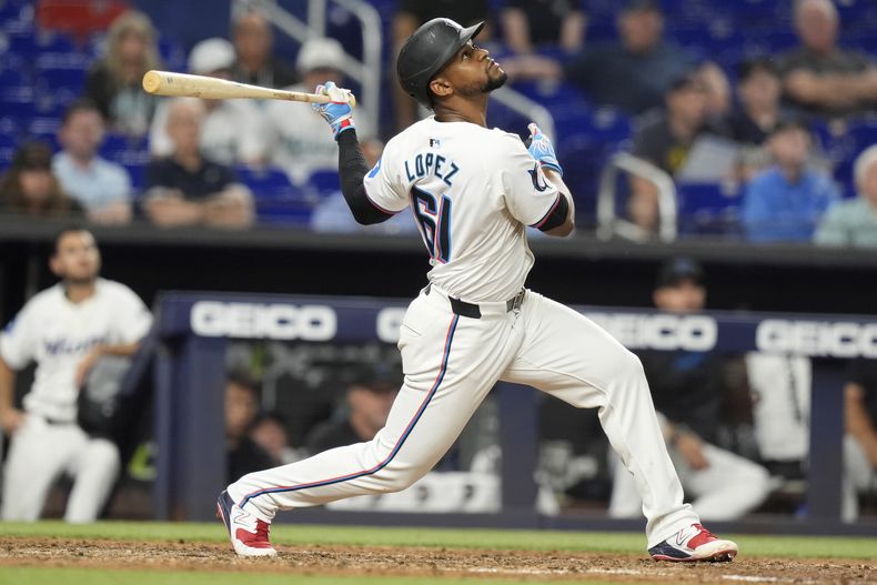 Otto Lopez (61), de los Marlins de Miami, da seguimiento a su sencillo productor que impulsó a Nick Gordon durante la nocena entrada del juego de béisbol en contra de los Cerveceros de Milwaukee, el lunes 20 de mayo de 2024, en Miami. (AP Foto/Lynne Sladky)