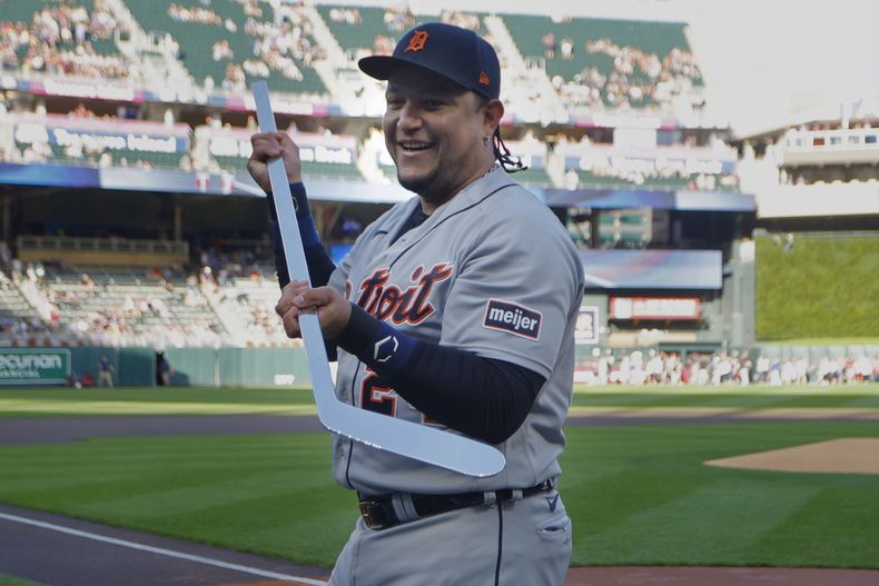 El venezolano Miguel Cabrera, de los Tigres de Detroit, sostiene un bastón de hockey, hecho de plata, que le obsequiaron los Mellizos de Minnesota el martes 15 de agosto de 2023 (AP Foto/Bruce Kluckhohn)