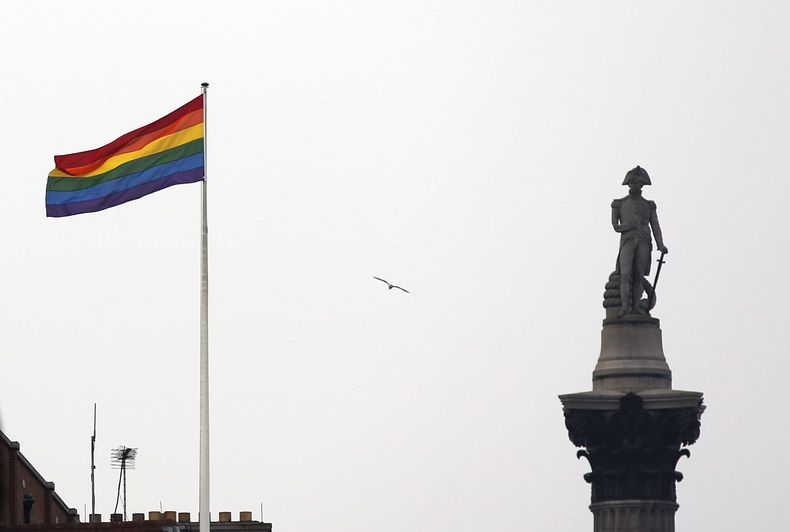 La bandera del arcoíris, símbolo de la comunidad lésbica, gay, bisexual y transgénero, ondea sobre un edificio junto al monumento de Nelson en Trafalgar Square en el centro de Londres, Gran Bretaña, el viernes 28 de marzo de 2014. (AP Foto/Lefteris Pitarakis, Archivo)