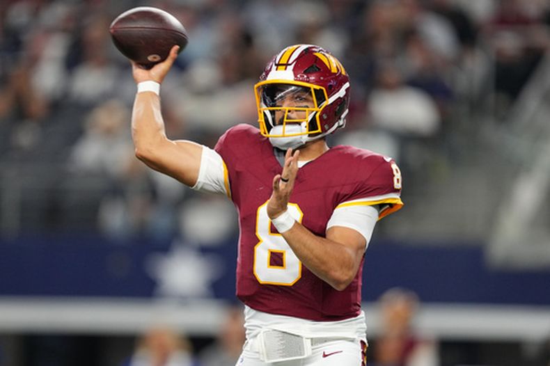 Marcus Mariota (8), quarterback de los Commanders de Washington, lanza un pase contra los Cowboys de Dallas en la segunda mitad del partido de la NFL del domingo 20 de septiembre de 2026, en Arlington, Texas. (AP Foto/Tony Gutierrez)