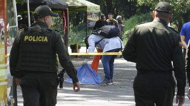 Un investigador forense inspecciona los restos de un hombre que murió cuando una motocicleta cargada con explosivos detonó en un puesto de control policial en la comunidad de Las Peñas de Jamundi, Colombia, el sábado 7 de diciembre de 2024. (Foto AP/Juan B Díaz)