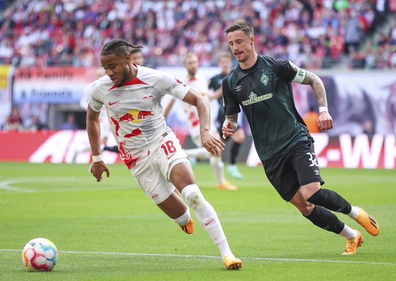 Christopher Nkunku (izquierda) de Leipzig y Marco Friedl del Werder Bremen pugnan por un balón en el partido de la Bundesliga, el domingo 14 de mayo de 2023. (Jan Woitas/dpa vía AP)
