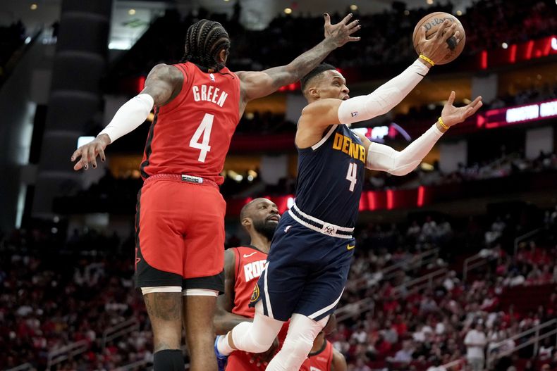 El escolta de los Nuggets de Denver, Russell Westbrook, a la derecha, conduce hacia la canasta superando al escolta de los Rockets de Houston, Jalen Green, durante la primera mitad de un partido de baloncesto de la NBA, el domingo 13 de abril de 2025, en Houston. (AP Foto/Eric Christian Smith)