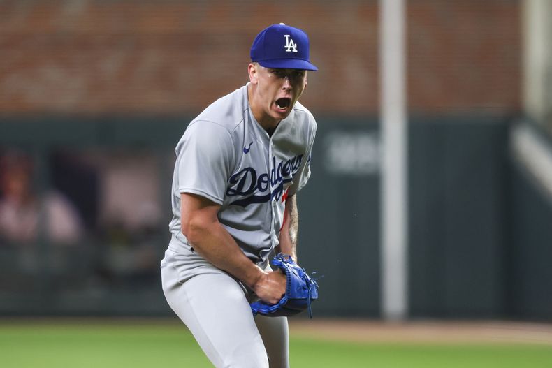 El abridor Bobby Miller, de los Dodgers de Los Ángeles, festeja tras conseguir un ponche ante los Bravos de Atlanta, durante el juego del martes 23 de mayo de 2023 (Jason Getz/Atlanta Journal-Constitution via AP)