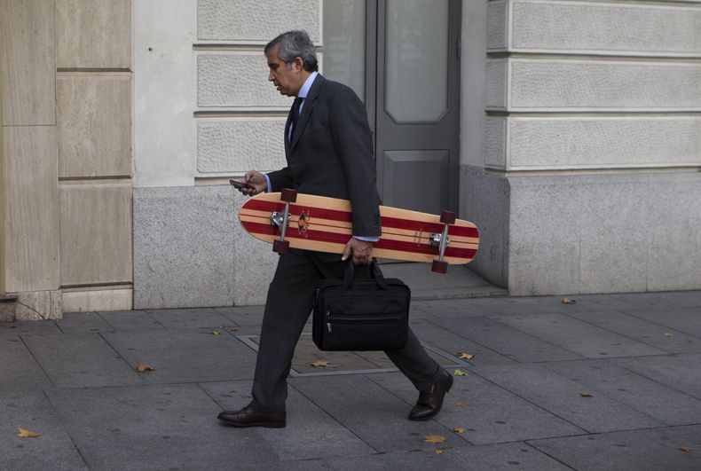 Un hombre que carga una patineta mira a su tel&eacute;fono m&oacute;vil en Madrid, Espa&ntilde;a, el lunes 4 de noviembre de 2013. La embajada de Estados Unidos en Madrid inform&oacute; que las actividades de espionaje a pol&iacute;ticos y ciudadanos de E