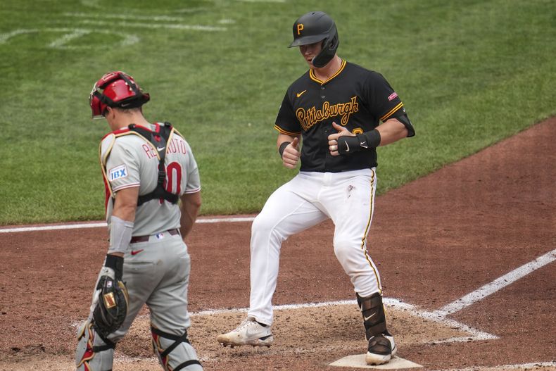 Henry Davis, de los Piratas de Pittsburgh, anota frente a J.T. Realmuto, receptor de los Filis de Filadelfia, en el juego del sábado 7 de junio de 2025 (AP Foto/Gene J. Puskar)