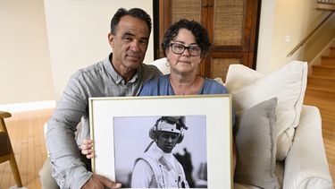 ARCHIVO - Derek y Suzi Alkonis posan con una foto de su hijo, el teniente de navío Ridge Alkonis, 1 de junio de 2022 en Dana Point, California, EEUU. El teniente de navío Ridge Alkonis, un oficial de la armada estadounidense encarcelado en Japón por un accidente de tráfico en que murieron dos ciudadanos japoneses, ha sido transferido a las autoridades estadounidenses, se informó el jueves 14 de diciembre de 2023. (AP Foto/Denis Poroy, File)