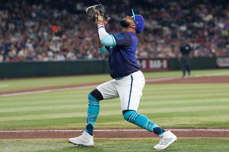 El dominicano Carlos Santana, primera base de los Diamondbacks de Arizona, atrapa un elevado en el juego del viernes 3 de abril de 2026, ante los Bravos de Atlanta (AP Foto/Rebecca Noble)