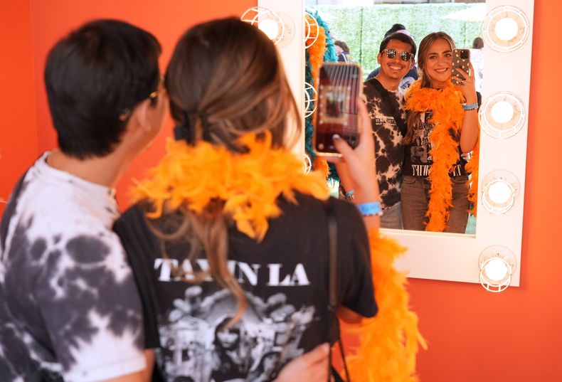 Roel Calderón, a la izquierda, y Ashley Miramontes se prueban prendas inspiradas en el nuevo álbum de Taylor Swift, The Life of a Showgirl, en un evento emergente de activación de fans de TikTok/Taylor Swift para celebrar el lanzamiento del álbum el viernes 3 de octubre de 2025, en Los Ángeles. (Foto AP/Chris Pizzello)