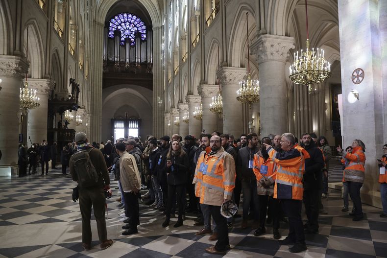 Trabajadores de la construcción que participaron en la restauración de la Catedral de Notre-Dame visitan el templo después del presidente francés Emmanuel Macron para ver los interiores restaurados, el viernes 29 de noviembre de 2024 en París. (Christophe Petit Tesson, Pool via AP)