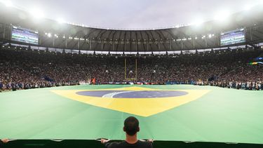 Unas cuadrillas despliegan una bandera brasileña en el terreno de juego antes de un partido de fútbol americano de la NFL entre los Cowboys de Dallas y los Ravens de Baltimore en Río de Janeiro, el 27 de septiembre de 2026. (Foto AP/Fernando Llano)