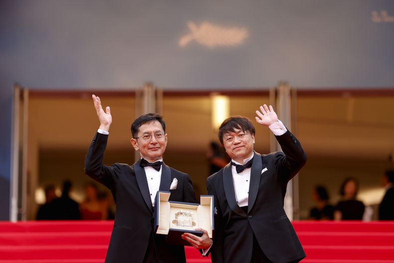 Goro Miyazaki, izquierda, y Kenichi Yoda posan para retratos con la palma de oro honoraria para el Studio Ghibli al llegar a la premiere de la película The Apprentice en la 77a edición del Festival de Cine de Cannes en Francia el lunes 20 de mayo de 2024. (Foto Vianney Le Caer/Invision/AP)