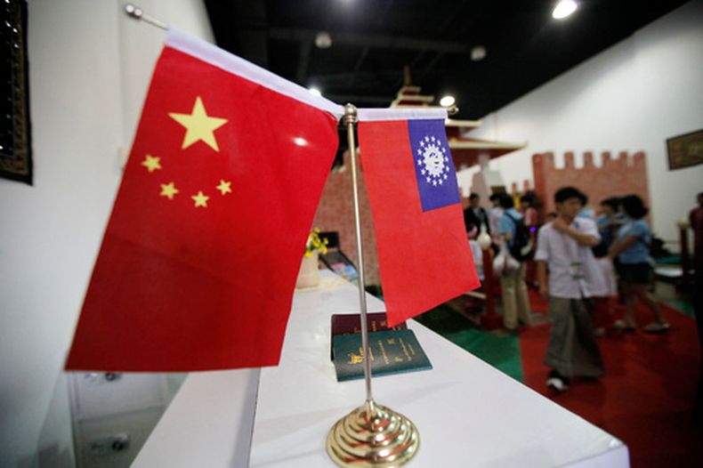 ARCHIVO - Banderas de China y Myanmar en la entrada del pabellón de Myanmar antes de la llegada del líder de la junta militar gobernante, el general Than Shwe, a la Shanghai Expo, en Shanghái, el 10 de septiembre de 2010. (AP Foto/Eugene Hoshiko, archivo)
